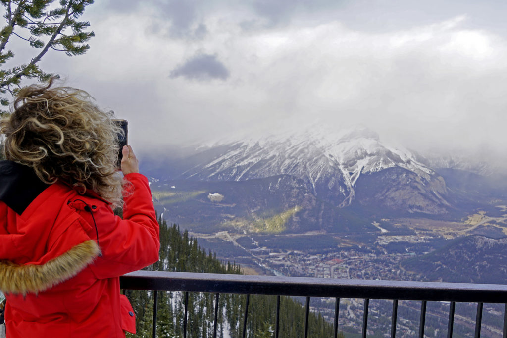 Emille snapping a photo with her cell phone of the Sulphur Mountain observation deck