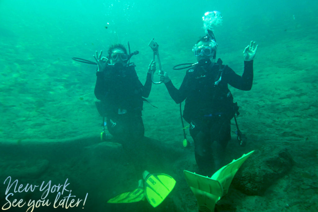 Dan and Emille in De Leon Springs sitting on a log underwater while holding the subway handle