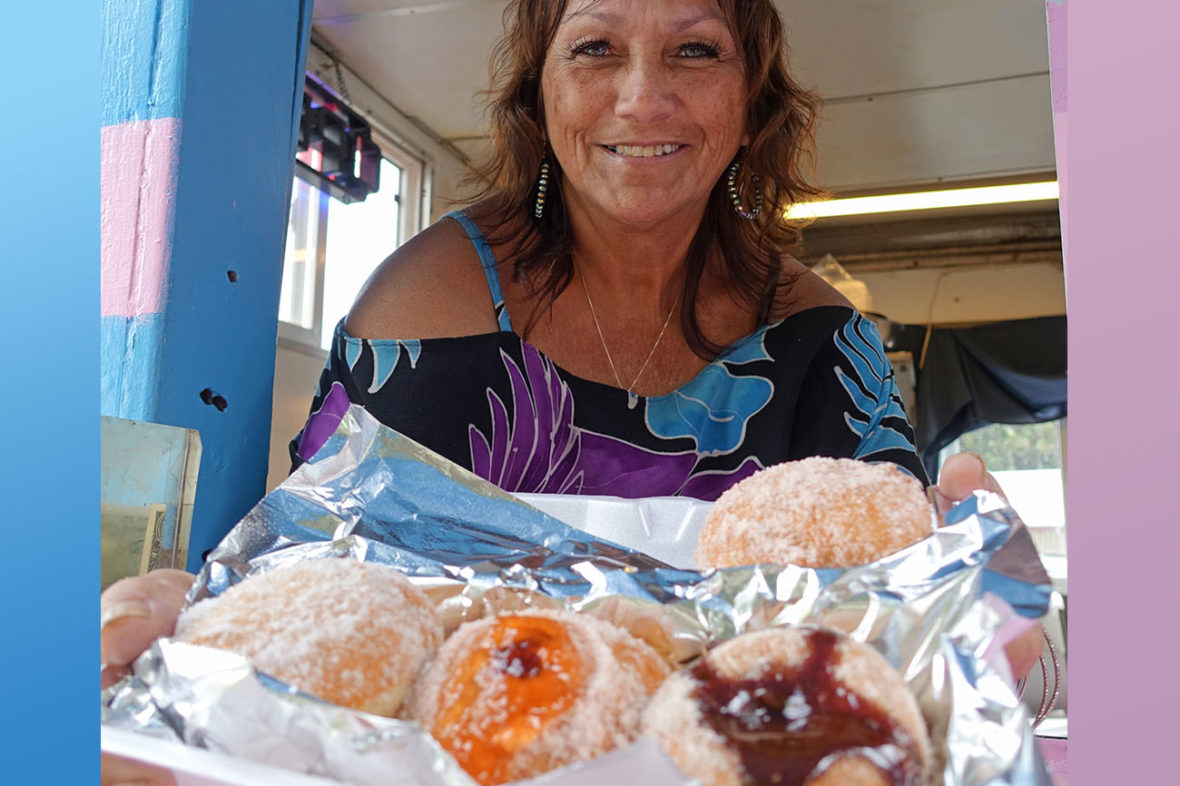 The owner holding delicious, hot malasadas in the Hot Malasadas Truck on The Big Island of Hawaii